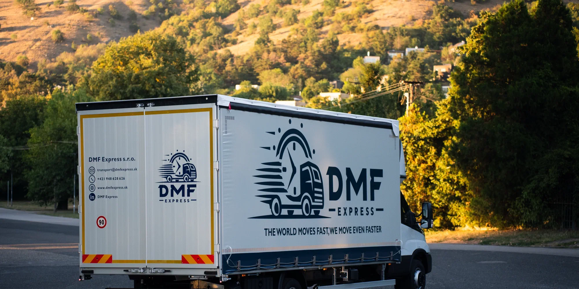 Rear of a DMF Express curtain-side vehicle showing hazard marking panels used for ADR transport